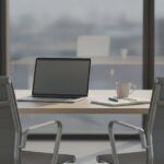 Leeg kantoorbureau met open laptop en koffiekop in het ochtendlicht